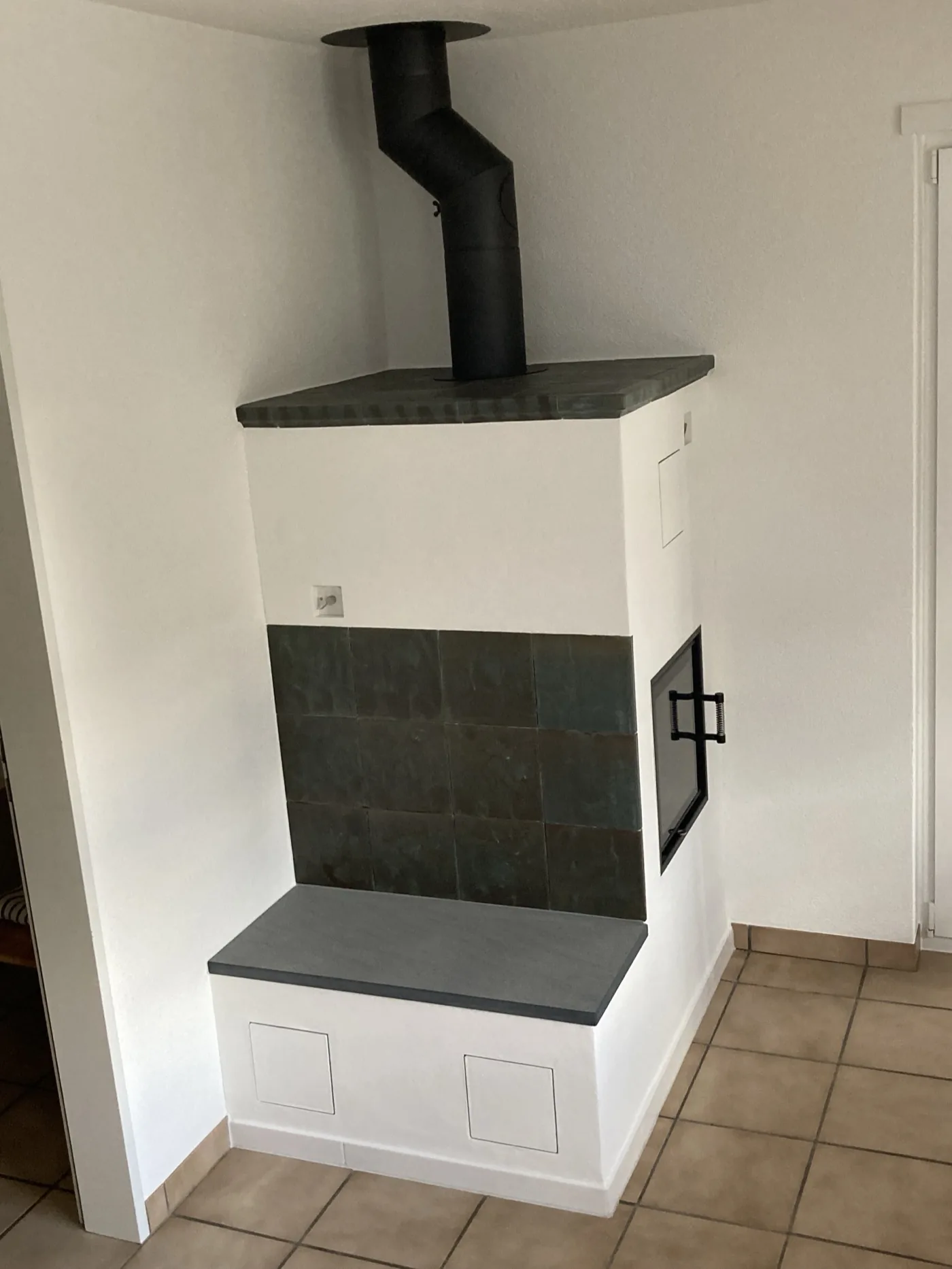 Speicherofen mit Natursteinkacheln und Sitzbank in Schaffhausen